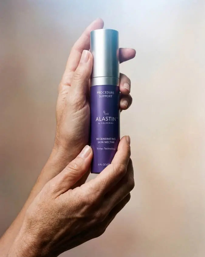 Hands holding bottle of Alastin Skin Nectar