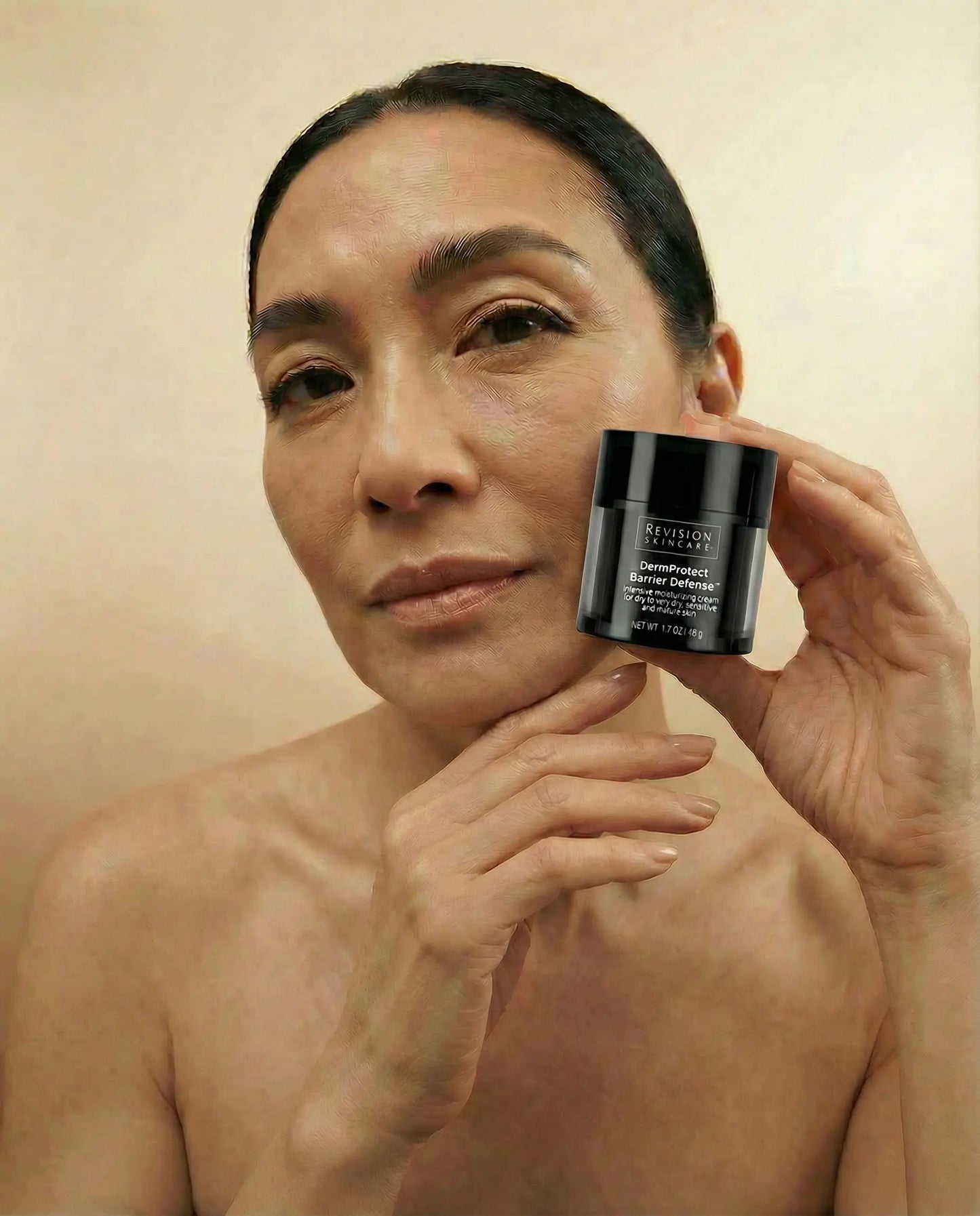 Beautiful woman holding Revision Dermprotect Barrier Defense 