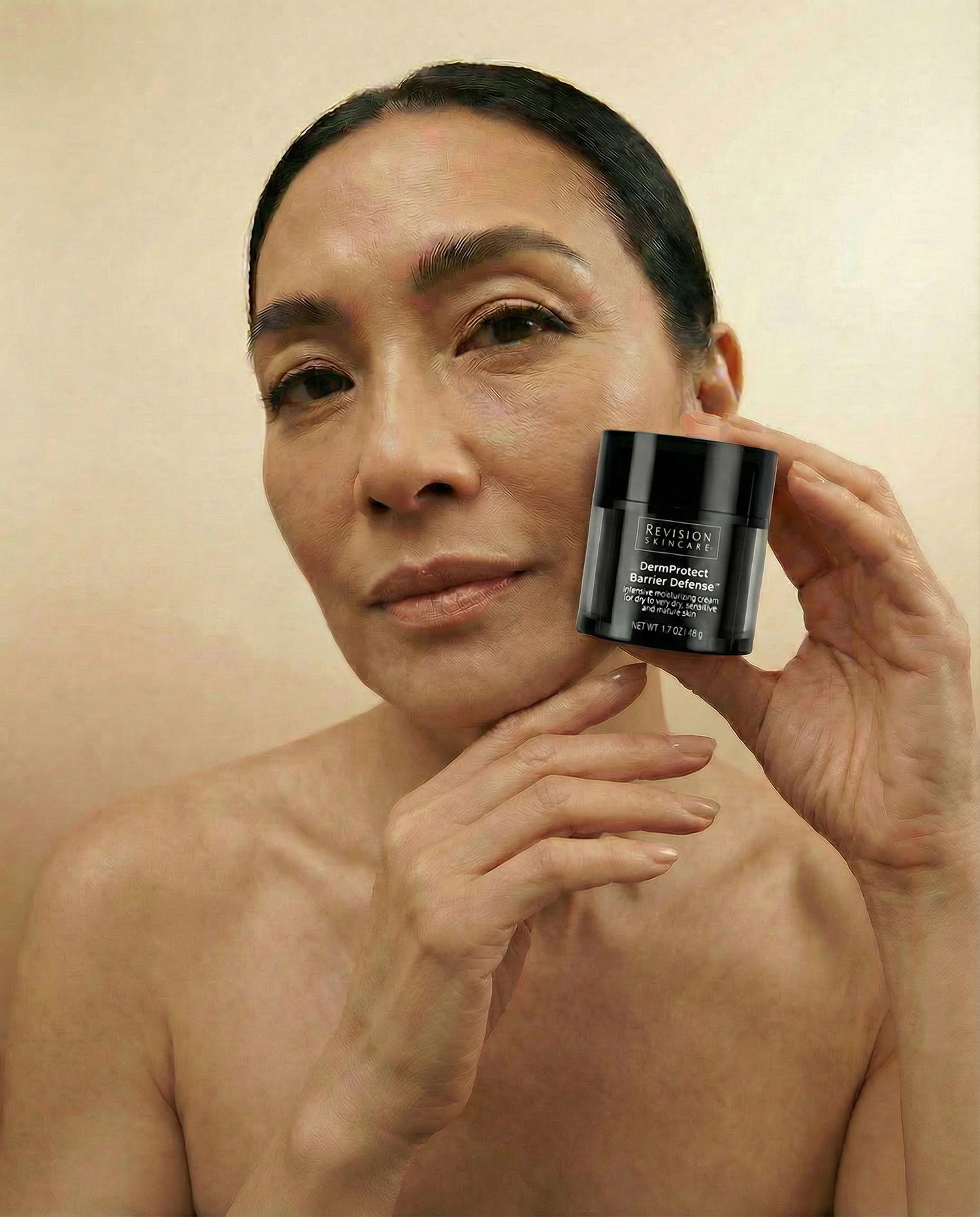 Beautiful woman holding Revision Dermprotect Barrier Defense 