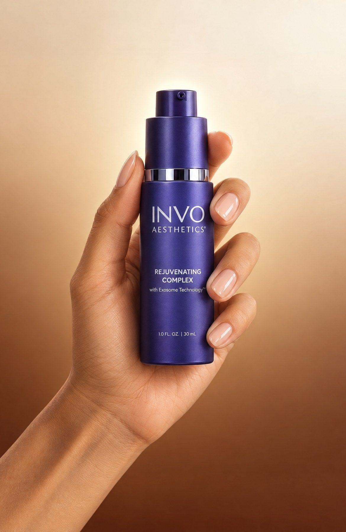 INVO Rejuvenating Complex exosome serum, 30 mL bottle held in hand against a warm gold background